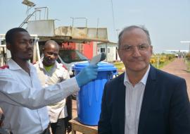 Dr Peter Salama, se faisant prendre la température par un agent du Programme national de l'hygiène aux frontières à l'aéroport de Mbandaka. OMS/Eugene Kabambi