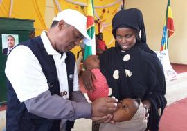 WHO Colleague vaccinating a child during the launching of mOPV2 vaccination WHO Colleague vaccinating a child during the launching of mOPV2 vaccination