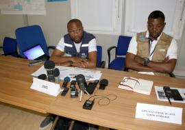 De gauche à droite, Dr Michel Yao, gestionnaire de la riposte pour l'OMS au Nord Kivu, et le Dr Bathé N'djoloko Tambwe, coordonnateur de la riposte contre Ebola pour le Ministère de la Santé au Nord Kivu lors du point de presse au Centre des opérations d'urgence à Beni – OMS/Eugene Kabambi. 