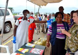 A Red Cross Volunteer demonstrates to WHO officials and other partners, how screening is done at the points of entry