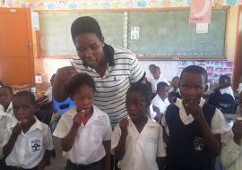 Children taking Albendazole for STHs deworming Children being assisted by a teacher to take Albendazole for STHs deworming