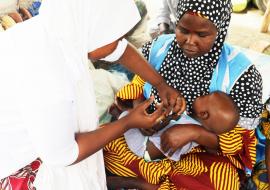 An eligble baby being immunized by Transit team in Muna Market, Maiduguri