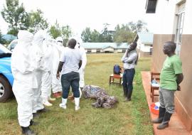 Ministry of Health and WHO staff teaching health workers proper donning and doffing of a Personal Protective Equipment
