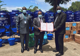 Dr Shongwe, WHO Representative, centre, handing over the certificate of donation to the Prof Gbakima, Minister of Technical and Higher Education