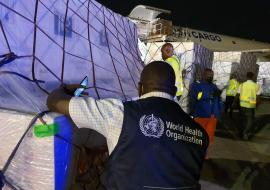 Un logisticien de l'OMS inspectant la cargaison contenant les doses de vaccins AstraZeneca contre la COVID-19 sur le tarmac de l'aéroport international de N'djili, à Kinshasa, juste après l'arrivée du cargo mardi 02 mars 2021 au soir.