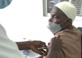 Mr. Sulayman Manneh, happily receiving the COVAX vaccine