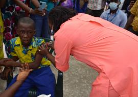 Health Minister, Dr. Jallah vaccinating first child during the TCV launch in Monrovia
