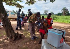 Children receiving vaccines under a tree in the hard-to-reach Nadiangere village in South Sudan