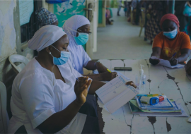 Health workers attending to a female patient in a health facility