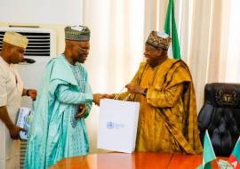 The Governor of Kano (right) receiving WHO Nigeria souvenirs from the WR