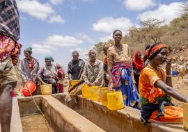 Des personnes attendent sous le soleil de midi que les abreuvoirs se remplissent d'eau à Hula Hula Springs, dans le comté de Marsabit, au Kenya. Avec la sécheresse qui sévit à Marsabit, la source est la seule source d'eau disponible pour toute la communauté. 