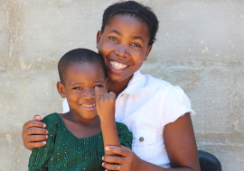 Elizabeth, a 7-year-old girl from Dukwi Refugee Camp in Botswana shows her marked finger after receiving her polio vaccine.