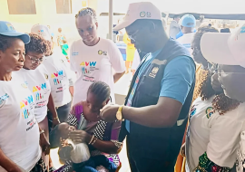 Figure 1A mother whose child is being vaccinated by a WHO staff as part of the commemoration of the African vaccination Week.png