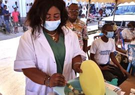 Une vaccinatrice tient un flacon de vaccin contre la fièvre jaune, lors d’une campagne menée en République démocratique du Congo. Crédit photo : OMS / Eugène Kabambi