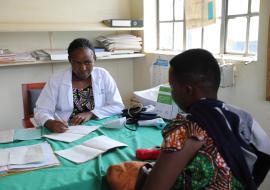 Jovita Atuheire a health worker at Maziba Health Center IV interacting with a patient 