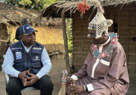 Dr John Otshudiema, épidémiologiste et gestionnaire adjoint de l’incident Ebola pour l’OMS, échange avec le chef coutumier Bidiaka. Ce dernier lui explique comment les rites ancestraux ont contribué à accélérer le contrôle de la maladie à virus Ebola dans la zone de santé de Bulape. Crédit photo : OMS/René Ifono