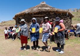 Parents from Mapholaneng community in Mokhotlong district displaying their children's vaccination card after participating in the MR campaign