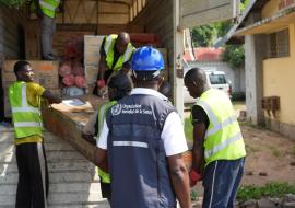 Déchargement des fournitures médicales de l’OMS destinées à l’installation d’une unité de traitement du choléra à proximité de l’hôpital de la Rive, dans la zone de santé de Binza Ozone, à l’ouest de Kinshasa. Cette initiative vise à renforcer la prise en charge des patients touchés par la maladie. – OMS/Joël Lumbala