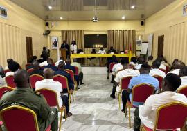 Participants seated in an auditorium attend the World Health Day ceremony, with officials at the front table.