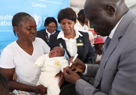 WHO Representative marking a vaccinated child