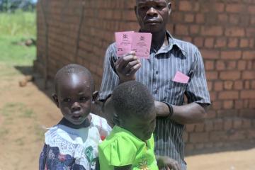 Proud father shows off his daughter's immunization cards Proud father shows off his daughter's immunization cards
