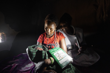 Neshoo Leaungokiok and her newborn baby, sits with Lucy Makena, a reproductive health officer from a nearby mobile outreach clinic supported by WHO. 