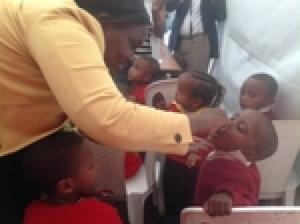 Dr Fiona Braka administering polio drops to a young boy at the NID launching event.