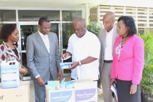 The WHO Representative, Dr. Rufaro Chatora hands over to the Permanent Secretary one of the water treatment tablets