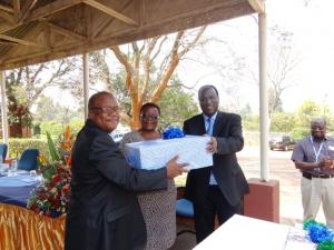 Dr Okello presenting farewell gift to Dr and Mrs Charimari