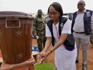 Dr Moeti washes her hands at the entrance of the District Emergency Response center in Port Loko, Sierra Leone. WHO / P. Desloovere