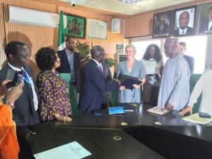 Permanent Secretary Ministry of Foreign Affairs Ambassdor Bulus Lolo exchanging signed documents with German KfW representative Dr Marga Kowalewski while WR representative Dr Rex Mapzanje (on the left) looks on