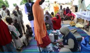 WHO supported Hard to Reach team staff weighs a pregnant woman during one of the outreach in Muna garage IDP camp in Maiduguri, Borno State