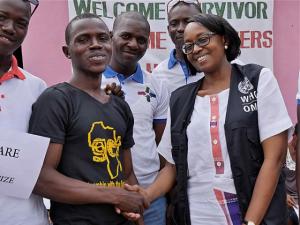 Dr Moeti shakes the hand of Sherrie Bangura (black t-shirt), Ebola survivor and founder of 'The Rescue Team', a network of Ebola survivors in Port Loko district. WHO / P. Desloovere