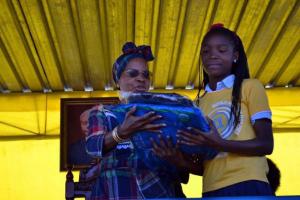 Dra Maria da Luz Dai Guebuza, fazendo a entrega à vencedora do concurso sobre a malária denominado: Sopa de Letras e Cultura Geral