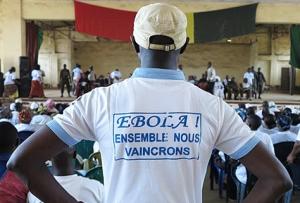 Man wearing tshirt with text "together we shall overcome Ebola" at a social mobilization event in Guinea WHO /Cristiana Salvi
