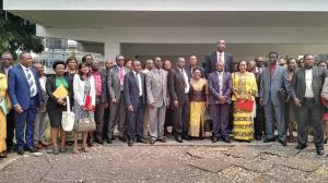 Photo de famille comprenant le Représentant de l’OMS en RDC, le Secrétaire général à la Santé Publique, l’ancien Basketteur de la NBA, Mutombo DIKEMBE et les autres participants à la réunion conjointe sur la lutte contre le cancer du col de l’utérus en RDC, devant la salle de conférence de l’OMS, à Kinshasa