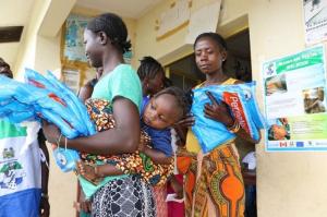 Families collecting their bed nets at a distribution point in Ngiehun Village in Kenema District, Eastern Sierra Leone