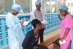 Healthcare workers screens  an actor patient during the simulation exercise , Slipway Clinic, Monrovia, May 30, 2017