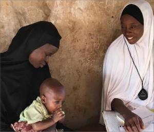 A community oriented resource person in Niger State examines a young child for pneumonia