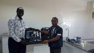 Mr Alex Freeman, handing over the water quality testing kit to the national public health laboratory technician in charge for water quality and safety testing.