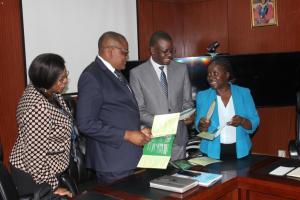 The WHO representative, dr. Nathan Bakyaita (second from right) at MOH when he handed over the MEC Wheel to the Permanent secretary, Dr. Kennedy Malama (second from left)