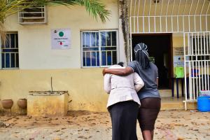 A patient supported by a relative into a health facility in Abuja