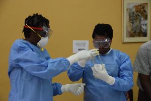 Health workers practice proper donning of protective gear during the training on vaccination 