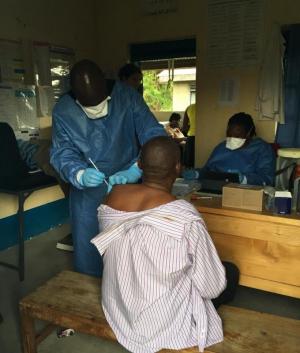 A member of the vaccinating team vaccinates a health worker in Rwebisengo