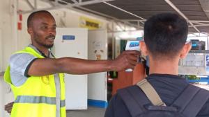 Primary screening includes temperature measurement and visual observation of travelers to look for signs of illness. © WHO/Tania Seburyamo  