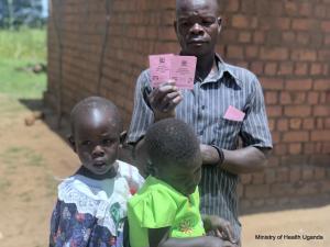Proud father shows off his daughter's immunization cards 