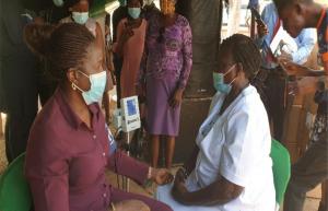 Ogun State Commissioner for Health, Dr. Tomi Coker checking her Blood pressure during the Launch of NHCI in Ogun State