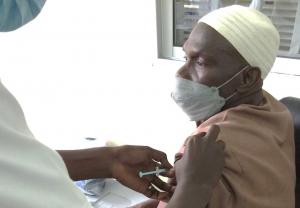 Mr. Sulayman Manneh, happily receiving the COVAX vaccine