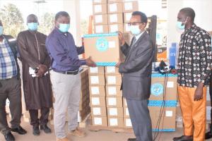 WHO Representative, Dr. Desta Tiruneh handing over a patient monitor to the Hon. Minister Dr. Ahmed Lamin Samateh