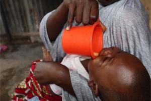 Hajara a caregiver, administering malaria drug to her eligible child